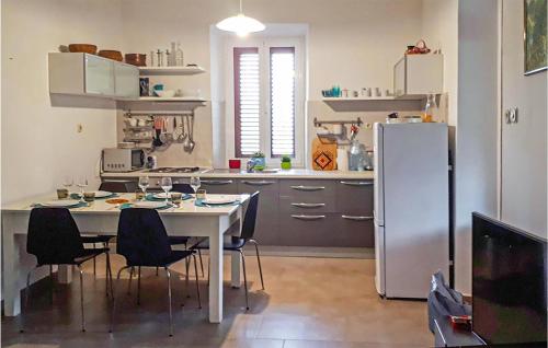 eine Küche mit einem Tisch und einem Kühlschrank in der Unterkunft Nice Apartment In Mali Iz With Wifi And 2 Bedrooms in Mali Iž