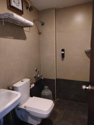 a bathroom with a toilet and a sink and a shower at Astra Hotels & Suites - HSR Layout Sector 1, Near Ecospace Bellandur in Bengaluru