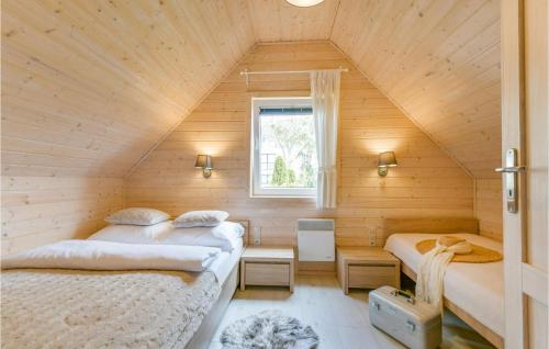 a bedroom with two beds in a wooden house at Beautiful Home In Ustronie Morskie With Kitchen in Ustronie Morskie
