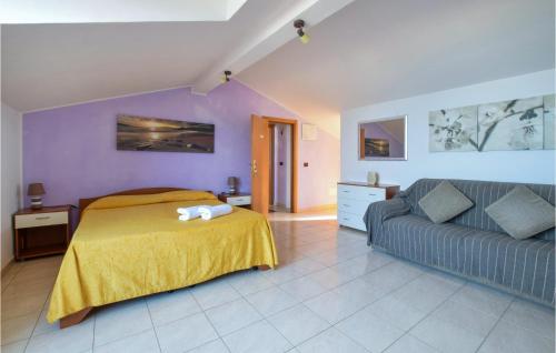a bedroom with a bed and a couch at 3 Bedroom Amazing Apartment In Castel Di Tusa in Castel di Tusa