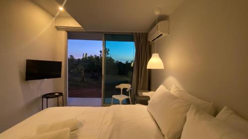 a bedroom with a white bed and a window at baan thammada in Nan
