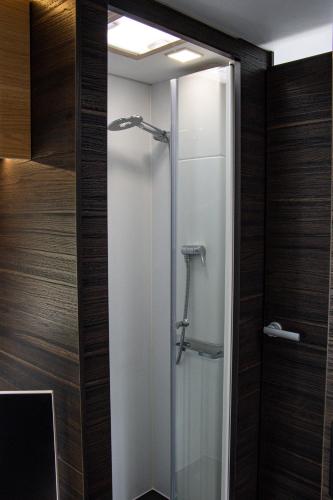 La salle de bains est pourvue d'une douche en verre et de murs en bois. dans l'établissement Gites Briffaut, à Saint-Hilaire-Fontaine