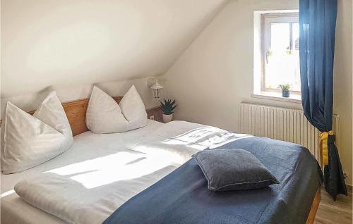 a bedroom with a bed with white pillows and a window at Lovely Home In Bad Waltersdorf With House A Panoramic View in Bad Waltersdorf