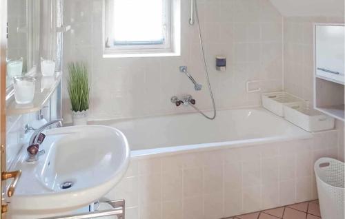 Baño blanco con bañera y lavamanos en Lovely Home In Bad Waltersdorf With House A Panoramic View, en Bad Waltersdorf