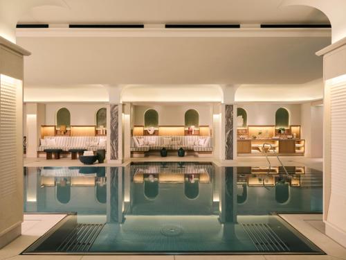 a pool in the middle of a room with a hotel at Rosewood Munich in Munich