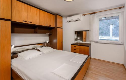- une chambre avec un grand lit blanc et une fenêtre dans l'établissement 2 Bedroom Lovely Apartment In Senj, à Senj