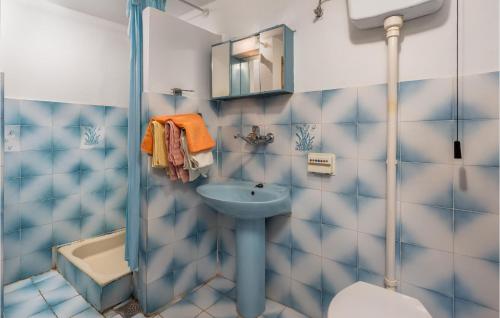 La salle de bains bleue et blanche est pourvue d'un lavabo et d'une douche. dans l'établissement 2 Bedroom Lovely Apartment In Senj, à Senj