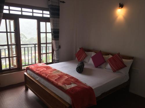 - une chambre avec un grand lit et une fenêtre dans l'établissement King's Lodge, à Nuwara Eliya