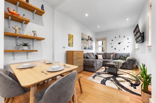 a living room with a table and a couch at Modern Spacious 1 Bed Flat near Richmond Park in London