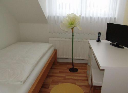 - une chambre avec un lit et une fleur dans l'établissement Venner Gasthaus, à Ostercappeln