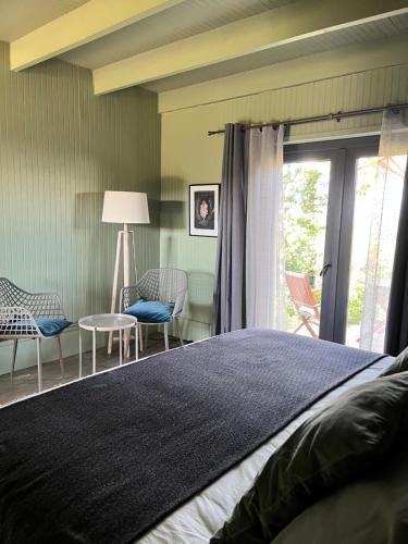 a bedroom with a bed and chairs and a window at La Guarda in Catapilco