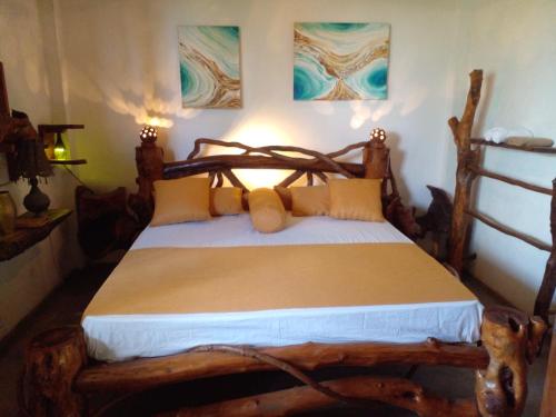 ディックウェラにあるSD3M ART GALLERY Villaのベッドルーム1室(木製ベッド1台、黄色い枕付)