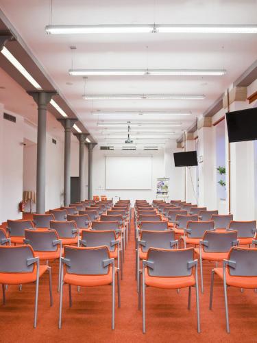 an empty lecture room with chairs and a podium at EA Business Hotel Jihlava in Jihlava