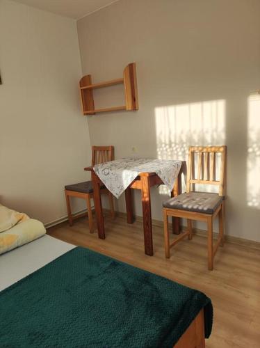 a room with a table and two chairs and a bed at DG EWA w Polańczyku in Polańczyk