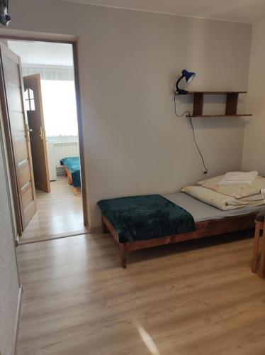 a bedroom with a bed and a door to a hallway at DG EWA w Polańczyku in Polańczyk