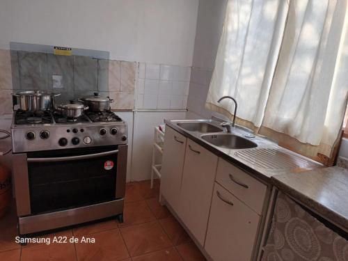 uma pequena cozinha com um fogão e um lavatório em Hostal Al Yaras em Coquimbo
