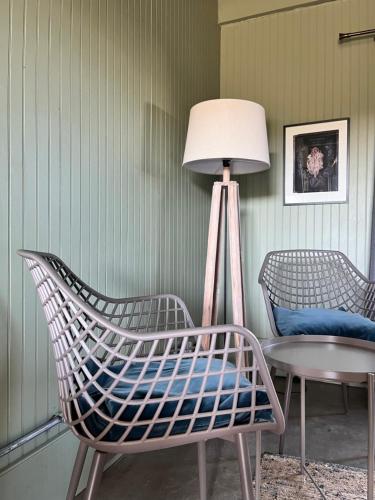 a room with two chairs and a lamp and a table at La Guarda in Zapallar
