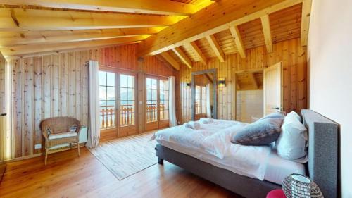 a bedroom with a bed in a room with wooden walls at Narnia SKI IN & SKI OUT chalet 14 pers in Les Collons