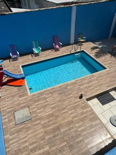 uma vista superior de uma piscina com cadeiras à sua volta em Casa para temporada super confortável 6km praia do forte Cabo Frio em Cabo Frio