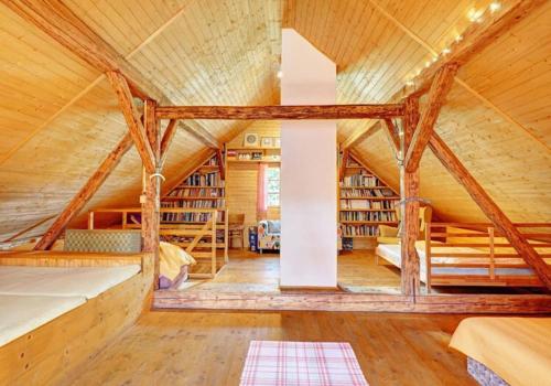 a wooden house with a large room with two beds at Chaloupka Malá Morávka in Malá Morávka