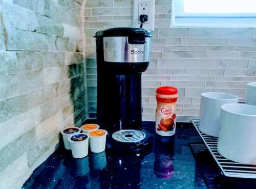 a coffee maker sitting on a counter with cups at MetroVista Short Stays in Mott Haven