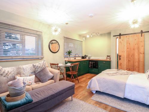 een woonkamer met een bank en een bed en een keuken bij Goldcrest Hide in Bungay