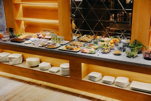 a buffet with plates of food on a table at DAMIR HOTEL in Nukus