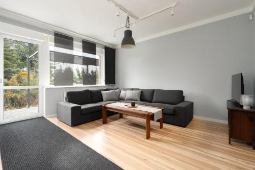 uma sala de estar com um sofá e uma mesa de centro em Dom Sianowska 130 m2, Parking & 3 Balkony Poznań by Renters em Poznań