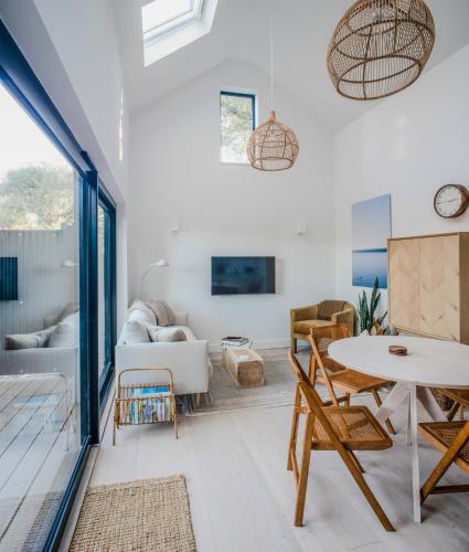 una sala de estar con una mesa y sillas en Lowen Tree House, en Truro