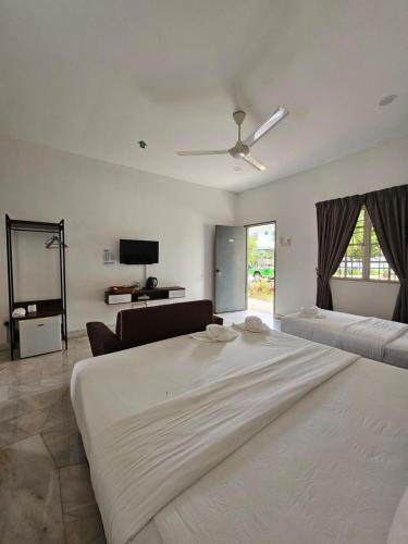 - une chambre blanche avec un grand lit et un canapé dans l'établissement LiLLA Summer Retreats formerly known as Karak Orchard Resort, à Kampung Sunjai Gapoi