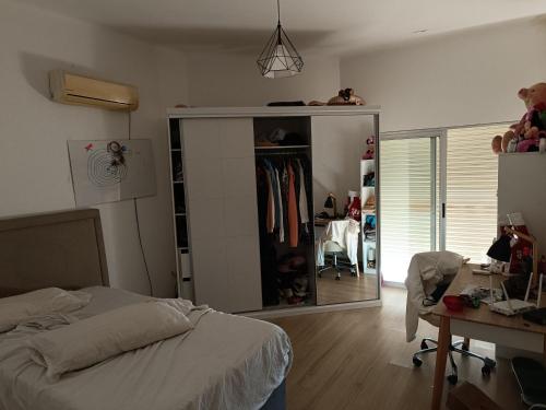 1 dormitorio con cama, escritorio y espejo en Casa 2 dormitorios Montevideo Pocitos en Montevideo