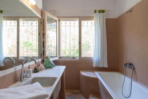 a bathroom with a tub and a sink and a mirror at Eklekti House in Firókambos