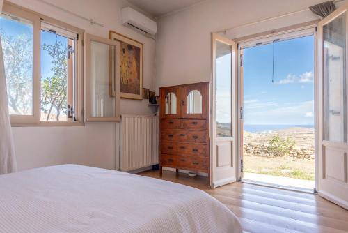 a bedroom with a bed and a large window at Eklekti House in Firókambos
