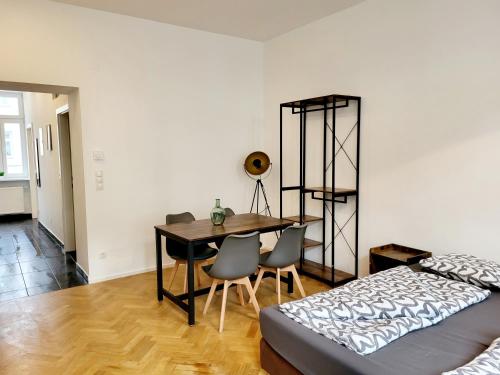 a bedroom with a table and chairs and a bed at Kienmayer Apartment Vienna in Vienna