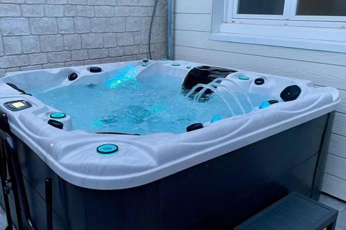 a jacuzzi tub in a room with a window at Le temps suspendu - Futuroscope in Jaunay-Clan