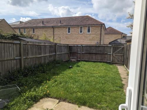 a backyard with a wooden fence and a green yard at Double rooms in Milton