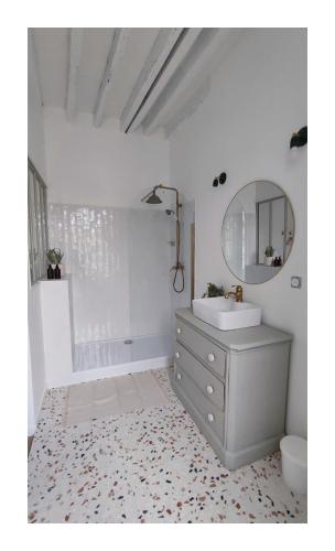 une salle de bain blanche avec un lavabo et un miroir dans l'établissement Maison Charmeilles - La suite Pomerol, à Fronsac