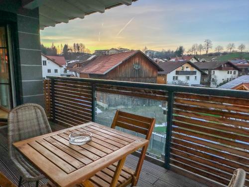 a wooden table and chairs on a balcony with a view at Sunset Club - Nesselwang Chalets Nr 2 in Nesselwang