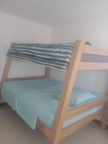 a wooden bunk bed with blue sheets on it at casa 4 cocorna in Cocorná