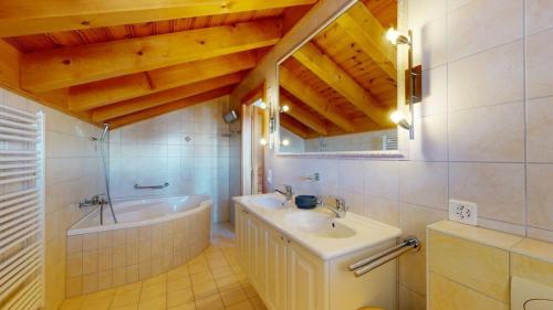a bathroom with a bath tub and a sink at Narnia SKI IN & SKI OUT chalet 14 pers in Les Collons