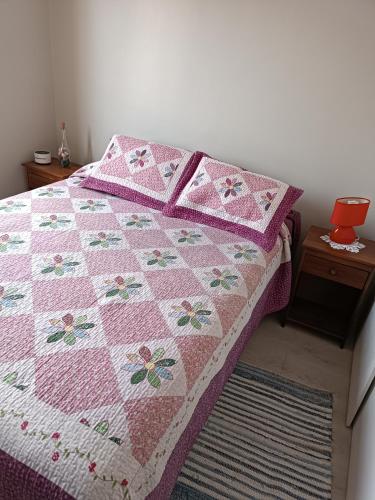 colcha rosa en una cama en un dormitorio en Haumaru Alojamiento habitación privada, en Santiago