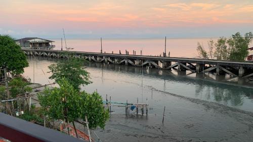 a bridge over a body of water at sunset at Limlay House Trat in Khlong Yai