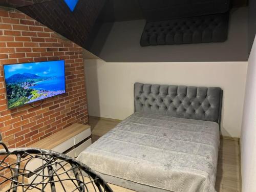 um quarto com uma cama e uma televisão numa parede de tijolos em RELAX VILLA 