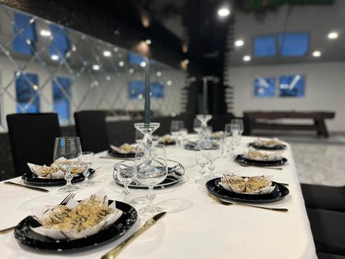 een lange tafel met borden eten en wijnglazen bij RELAX VILLA 