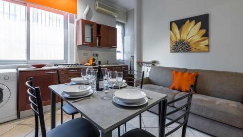 a dining room table with chairs and a couch in a kitchen at Inalpi Arena Suite Elegante Cromoterapia in Turin