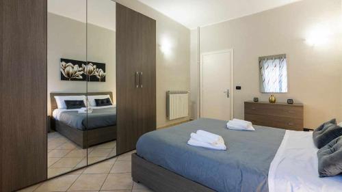 a bedroom with two beds and a mirror at Inalpi Arena Suite Elegante Cromoterapia AC in Turin