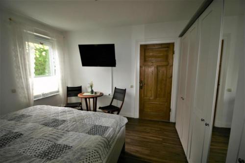 a bedroom with a bed and a table and a television at Haus zur Eiche 1 in Dahme