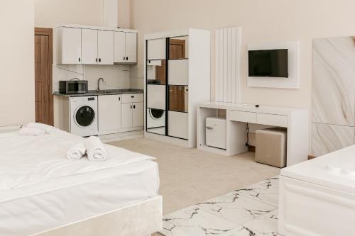 a white room with a bed and a kitchen at Chateau Milisi in Batumi