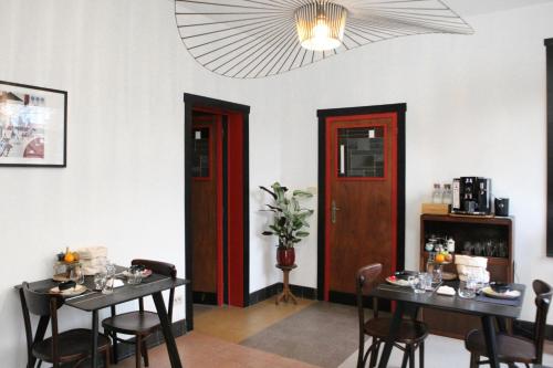 a dining room with two tables and two red doors at B&B Huis Billiet in Bruges