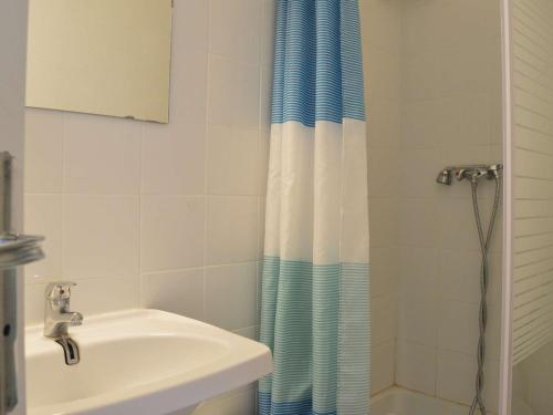 une salle de bain avec un lavabo et un rideau de douche dans l'établissement Appartement moderne avec terrasse à 1500m de la plage, parking privé, lave-linge, 4 couchages - FR-1-249-177, au Cap d'Agde